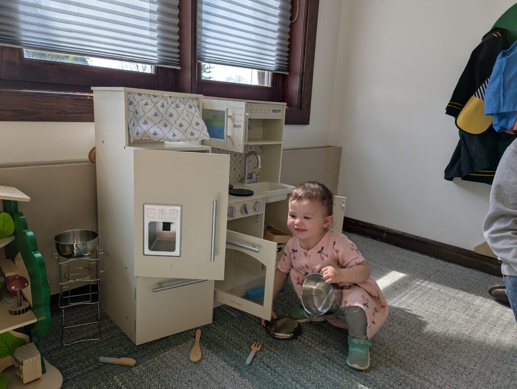 child playing with toy kitchen