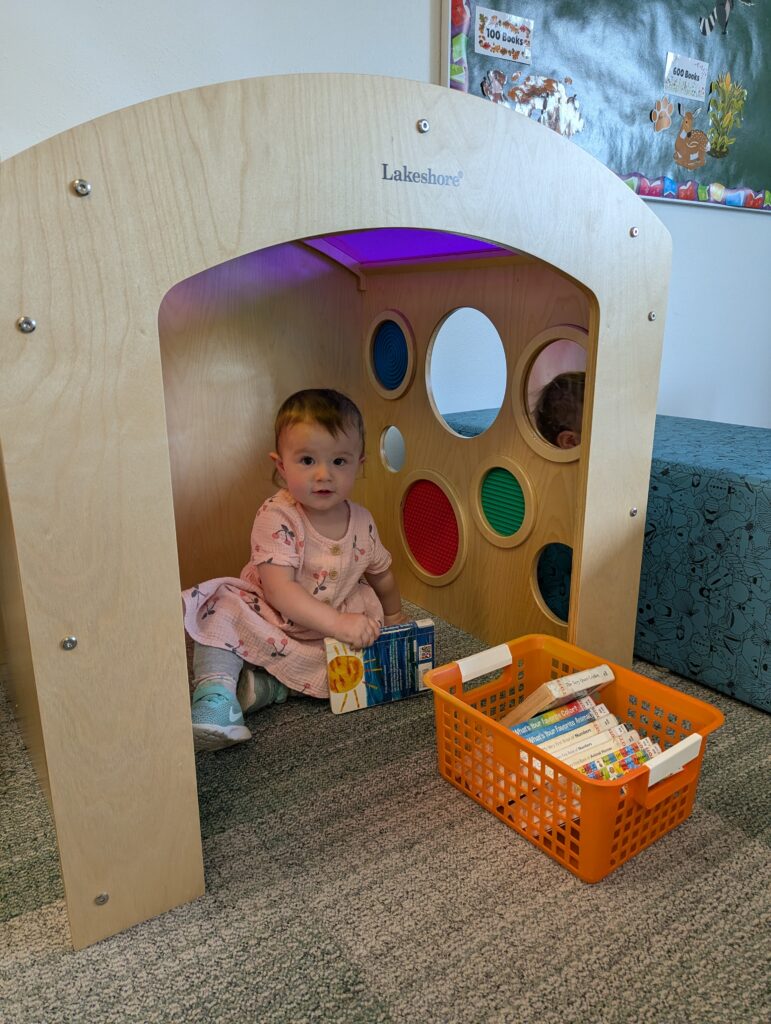 child in play house with books